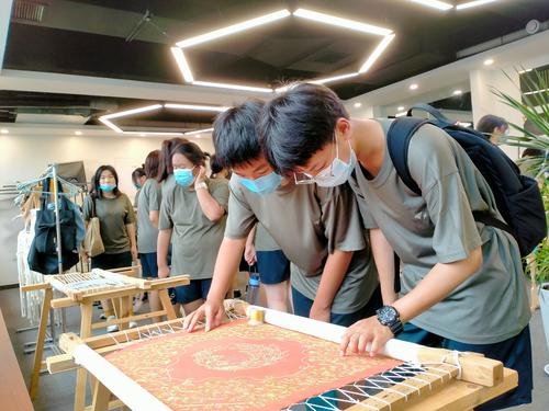 13.学生认真欣赏刺绣作品