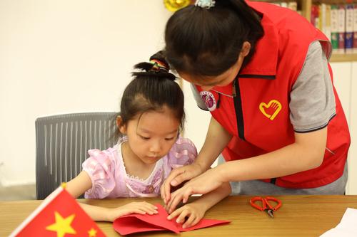 3团员志愿者帮助小朋友完成折纸