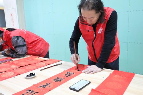 2中国书法家协会会员、郑州艺术幼儿师范学校高级讲师孟建军带领学生书写春联